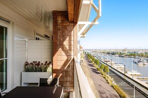 A balcony with a view of a marina, a white railing, and a potted plant with flowers. - Southampton 17 0302 + G38 (Nieuwpoort)