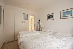 A bedroom with a large bed, a wardrobe, and a door leading to a bathroom.