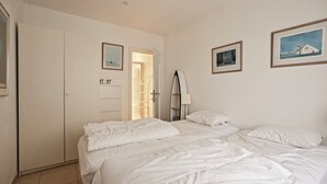 A bedroom with a large bed, a wardrobe, and a door leading to a bathroom. - Zonnehaven II G 0002+G93 (NIEUWPOORT)