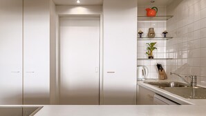 A modern kitchen with white cabinetry, a stainless steel sink, and a countertop.