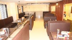 A restaurant with booths and tables, some with condiments and napkins. - SAS SQUARE (Tiruchirappalli)