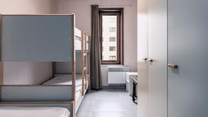 A dormitory room with bunk beds, a window with curtains, a radiator, a desk, and a door. - 2 bedroom accommodation in Oostduinkerke (Oostduinkerke)