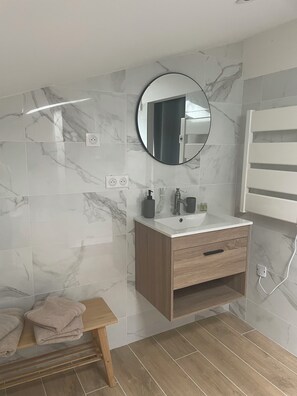 Chuveiro, secador de cabelo, toalhas de banho, papel higiênico