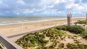 Een strand met een hoge zendmast, een zandstrand en een weg naar het strand.
