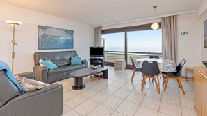 Un salon moderne avec un canapé, une table basse et un coin repas.