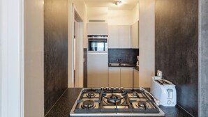 A modern kitchen with a gas stove, a built-in oven, and a toaster. - 2 bedroom accommodation in Koksijde (Koksijde)