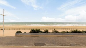 A paved walkway leading to a beach with a railing and a street lamp. - 2 bedroom accommodation in Koksijde (Koksijde)