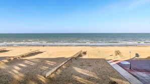 A beach with a clear sky, a sandy shore, and a calm sea. - Idesende 2/0203 + P* (Sint Idesbald)