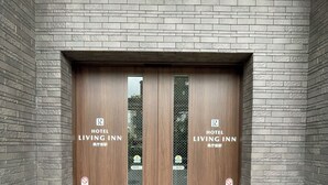A double door entrance to a hotel with a brick facade and a tiled floor. - Hotel Living Inn Kenchoumaeeki (Naha)