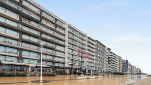Un hôtel à plusieurs étages doté de balcons, d’un espace extérieur aménagé et offrant une vue sur le front de mer.