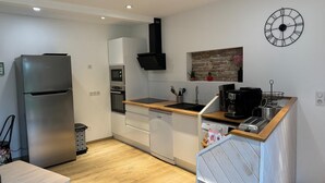A modern kitchen with a stainless steel refrigerator, built-in oven, and a coffee machine. - Guest House : Lo Refugi  (Pechbonnieu)