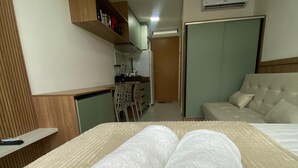 A hotel room with a bed, a sofa, a kitchenette, and a bathroom. - Villas do Porto - 108 by La Playa (Ipojuca)