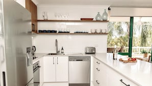 A modern kitchen with white cabinets, a dishwasher, a toaster, and a view of the outdoors. - Headlands Beachside Gem - 50mtrs To Toes In Sand! (Alexandra Headland)