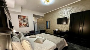 Un dormitorio moderno con una cama grande, un televisor de pantalla plana, un armario y un escritorio con silla.
