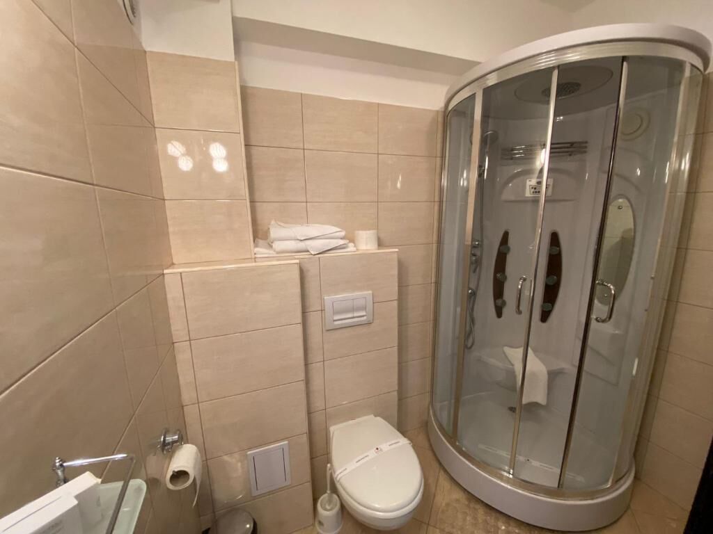 Un baño con ducha de vidrio, inodoro y lavamanos.
