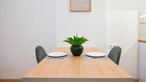 A conference table with two chairs, a potted plant, and a framed picture on the wall. - Athens Syntagma Ermou (Athens)