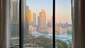 Vista panorámica de la ciudad desde un rascacielos, con varios edificios altos, una gran fuente y una masa de agua.