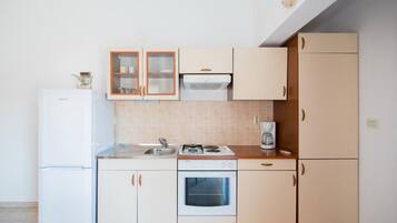 Een koelkast, een oven, een kookplaat, een koffiezetapparaat/waterkoker