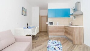 A compact living space with a kitchenette, a dining area, and a sofa. - Apartments Marmo - Superior One Bedroom Apartment with Balcony and Sea View (Apartman 3) (Mlini)