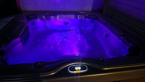 A hot tub with a digital control panel and a purple light.