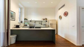 Eine kompakte Küche mit integriertem Mikrowellenherd, Spüle und Kühlschrank.
