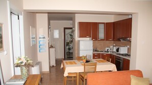 A compact living space with a dining area, kitchenette, and a sofa.
