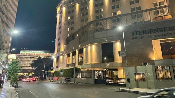 A multi-story hotel with a prominent entrance and signage for "Steigenberg Hotel El Tahrir". - One Season Hostel (Cairo)