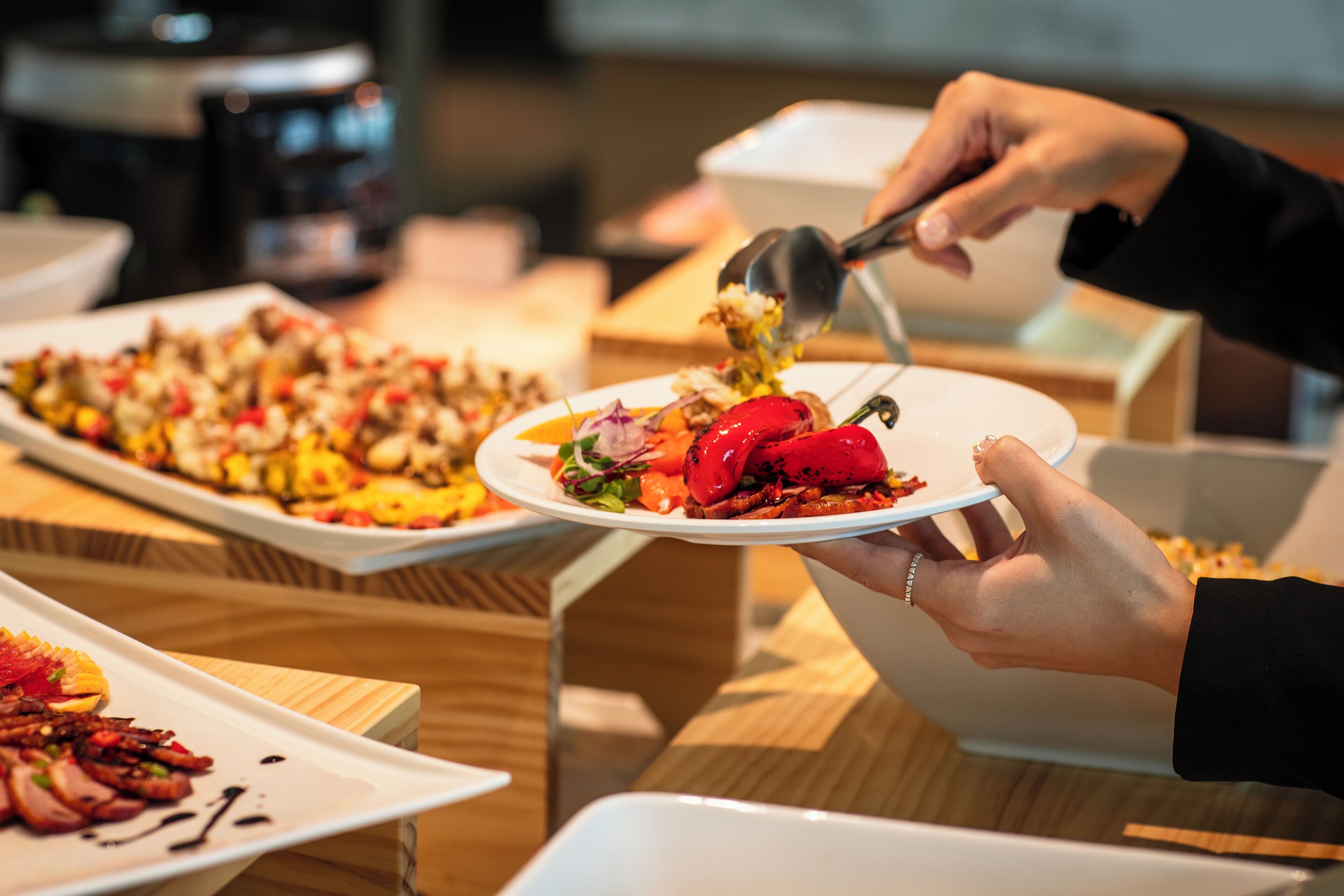 A person serving food from a bowl onto a plate.