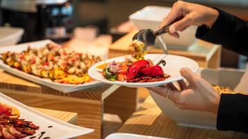 A person serving food from a bowl onto a plate.