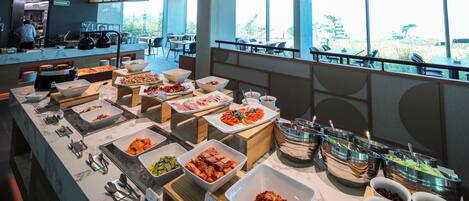 A buffet with various food items and a view of the outdoors.