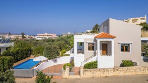 A modern two-story house with a swimming pool, stone walls, and a view of the sea. - Villa Katerina (Chania)