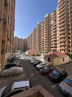 A parking lot with multiple cars and a small building with a red roof. - Private Spacious Apartment close to Center, Baku (Bakı)