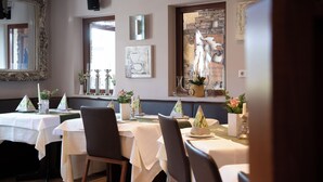 A dining area with tables set for two, featuring white tablecloths and decorative centerpieces. - Zu den drei Kronen (Seligenstadt)