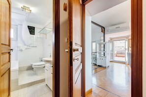 Et moderne badeværelse med badekar, toilet og håndvask.