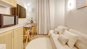 A compact living space with a kitchenette, a dining area, and a sofa.