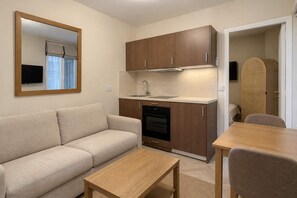 A compact living space with a kitchenette, a sofa, a coffee table, and a dining area. - Charmant cocon à Belleville • Paris • 3 personnes (Paris)