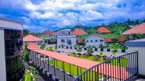 Un patio con un edificio de techo rojo, un edificio blanco con un letrero azul y un edificio moderno de vidrio.
