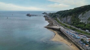 Une route côtière bordée d’une plage et d’une jetée.