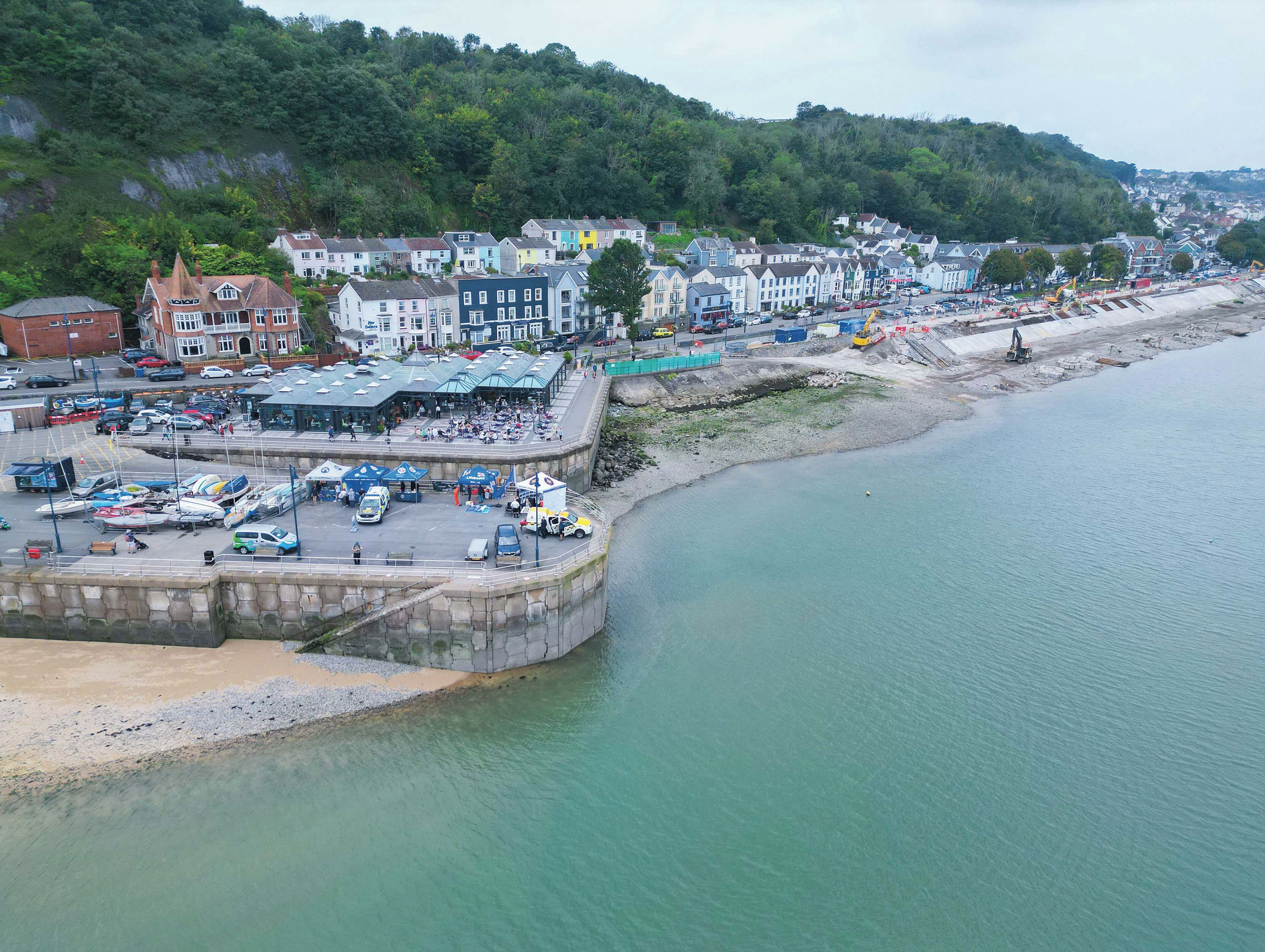 A coastal town with a marina, colorful houses, and a rocky shoreline.