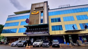 A hotel with a modern facade, multiple parking spaces, and a visible sign for Urban Place Cafe & Resto. - MP Hotel Kelapa Gading (Jakarta)