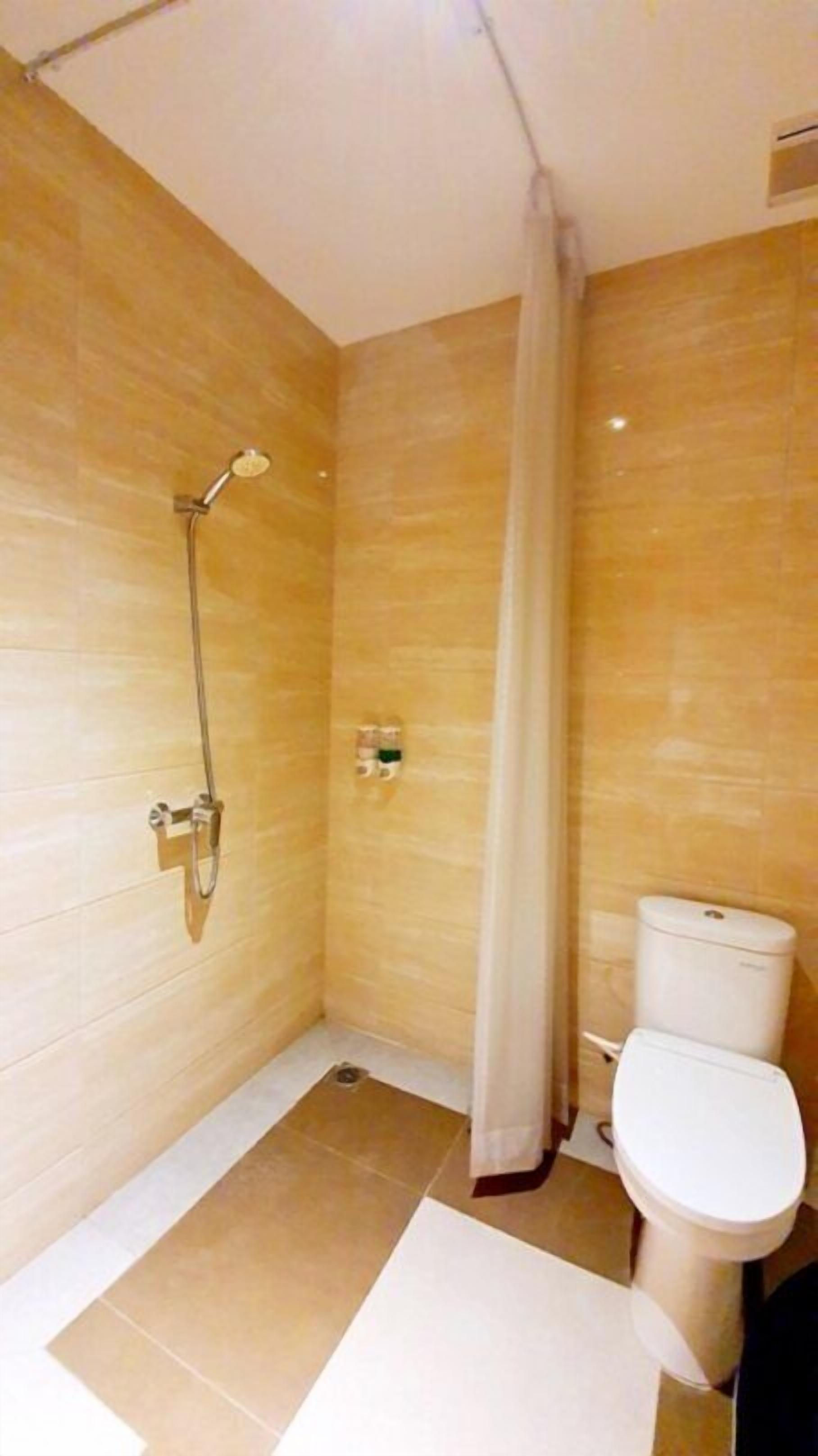 Un bagno piccolo e moderno con doccia, toilette e pavimento piastrellato.