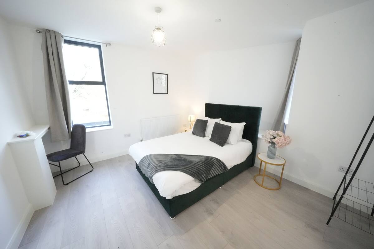 A modern bedroom with a bed, a desk, and a chair.