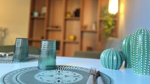 A dining table with a decorative centerpiece, a wooden cabinet in the background, and a hanging light fixture.