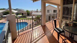 A covered balcony with a pool, a table, and chairs. - Pelican Shore Villa 14 - Kalbarri WA (Kalbarri)