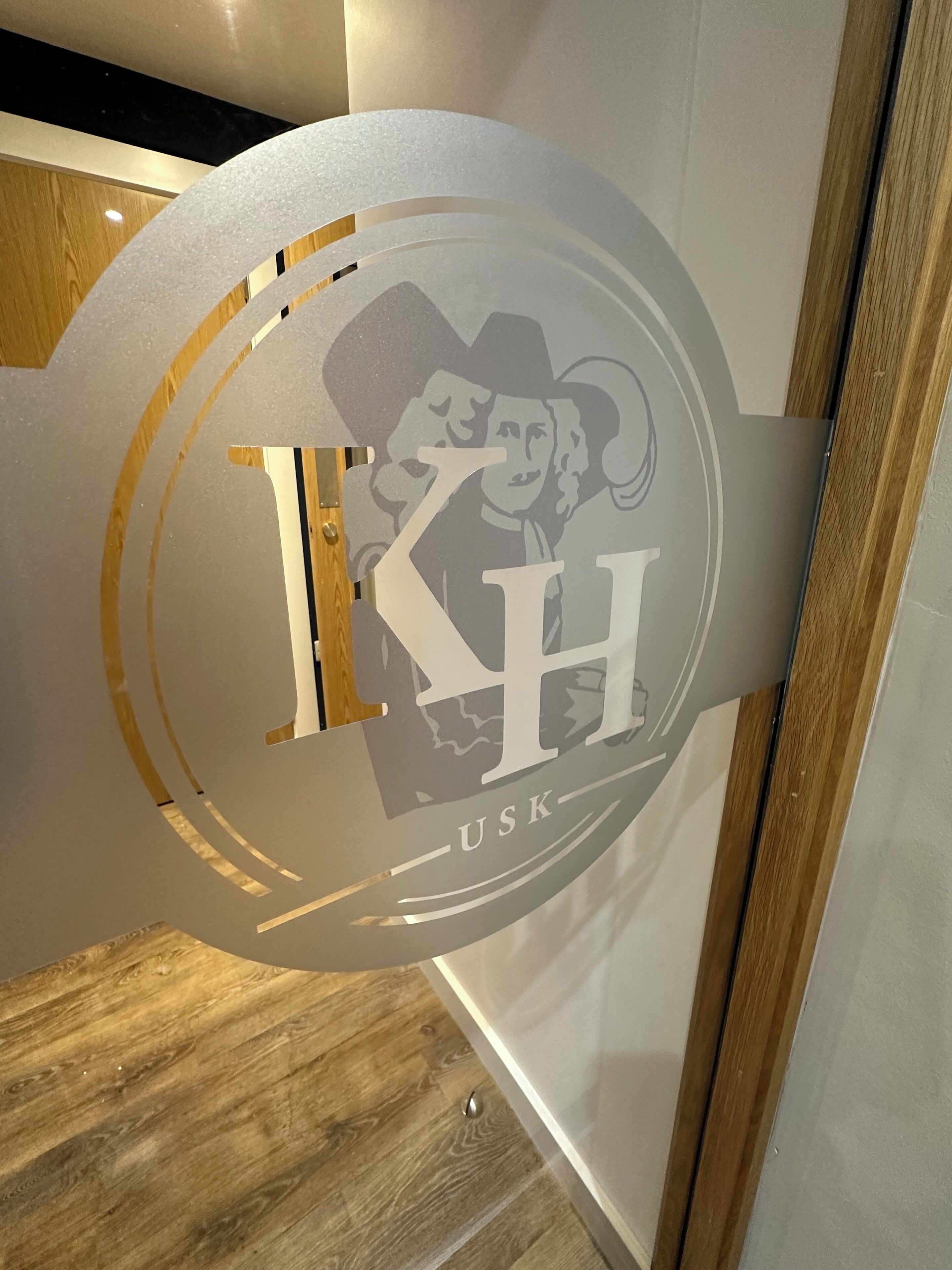 Et rundt skilt med et logo og bogstaverne 'IHS' og 'USK'.