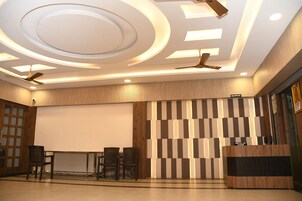 A reception area with a modern design, including a reception desk, seating area, and a large screen.