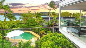A pool surrounded by lush greenery, overlooking a scenic ocean view. - Oasis 21, Oasis 21 on Hamilton island (Hamilton Island)