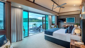 A modern hotel room with a large bed, a ceiling fan, a TV, and a view of the sea. - Yacht Club Villa 29, Yacht Club Villa 29 on Hamilton Island (Hamilton Island)