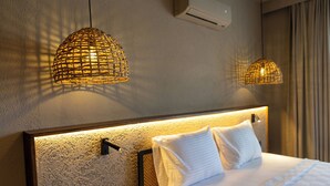 A hotel room with a large bed, two wall-mounted lamps, and a textured wall. - SEA SOUL OTEL (Bodrum)