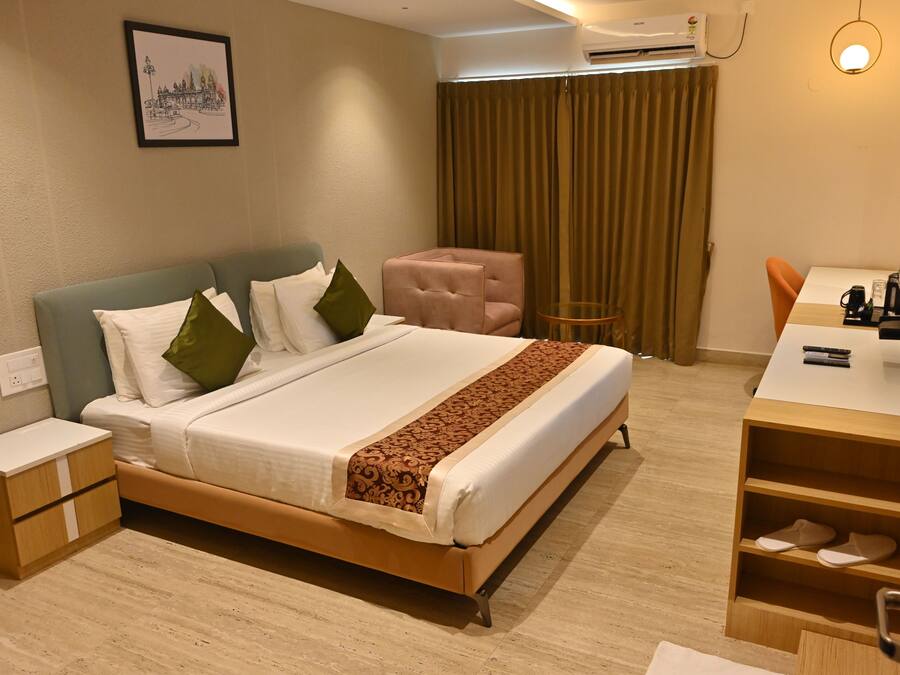 Una habitación de hotel con cama, escritorio, silla y televisor.